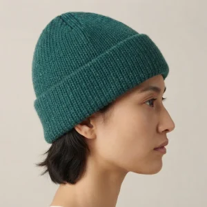 Person in profile wearing a teal ribbed knit alpaca beanie