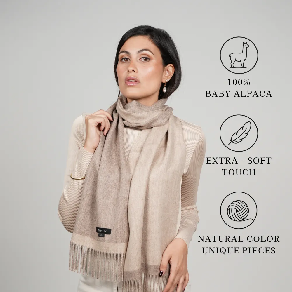 Woman model wearing an alpaca scarf in beige reversible “100% BABY ALPACA,” “EXTRA-SOFT TOUCH,” and “NATURAL COLOR UNIQUE PIECES.”