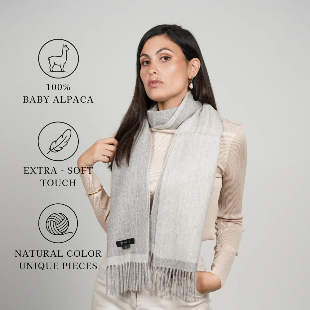 Woman model wearing an alpaca scarf in gray reversible “100% BABY ALPACA,” “EXTRA-SOFT TOUCH,” and “NATURAL COLOR UNIQUE PIECES.”