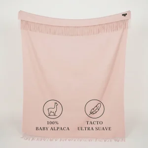 Manta de baby alpaca rosa pastel extendida con flecos y textura suave